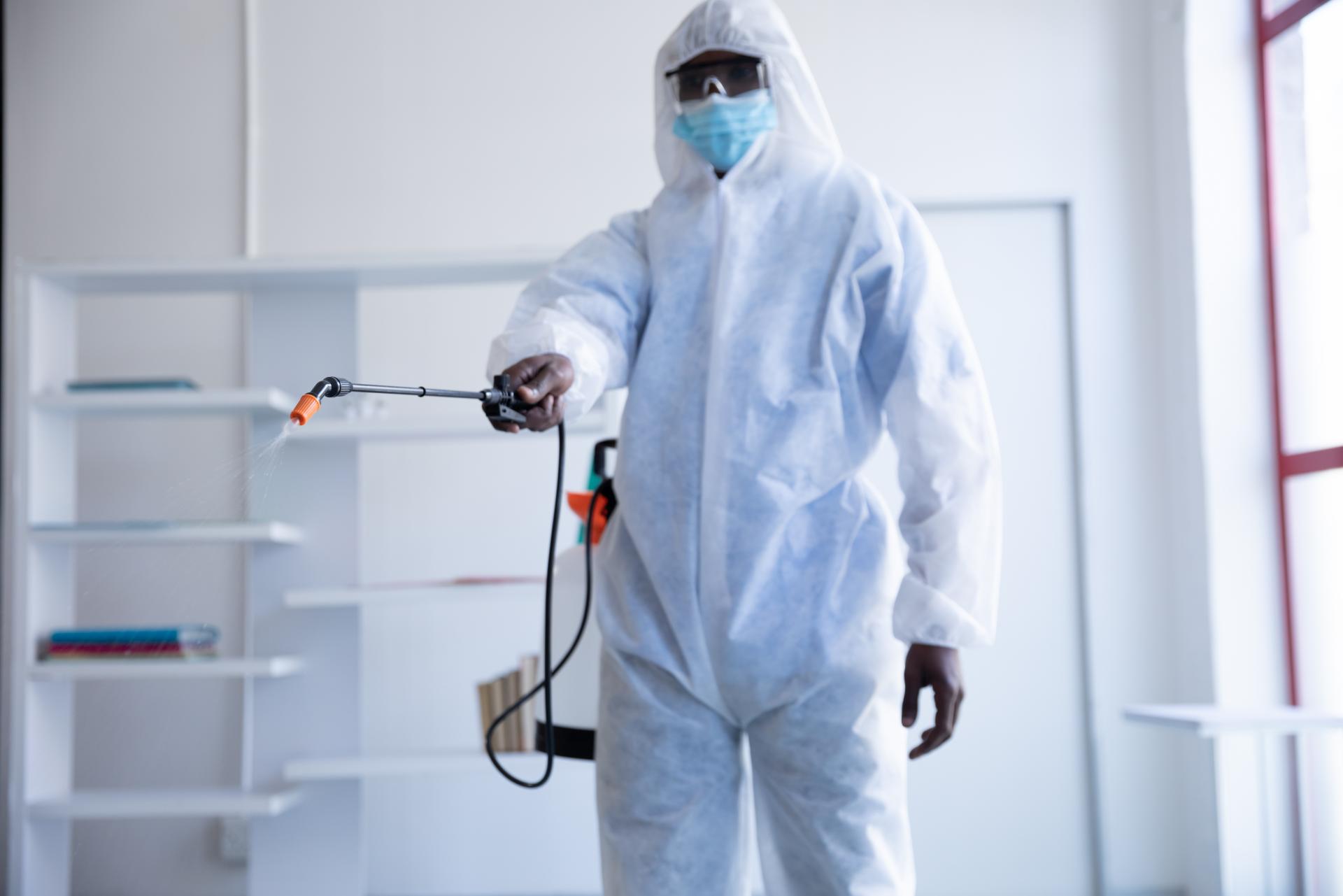 NexHive pest control technician spraying treatment in an office space